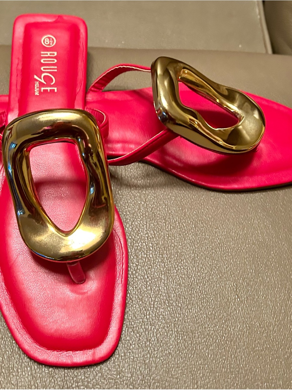 Sleek red leather slide sandals with a chic gold sculptural accent. 8.5